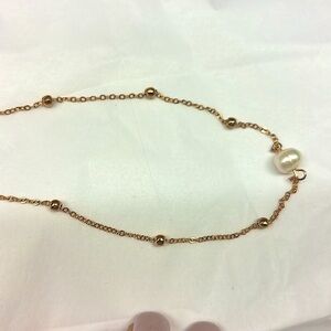 Simple gold chain with single middle pearl